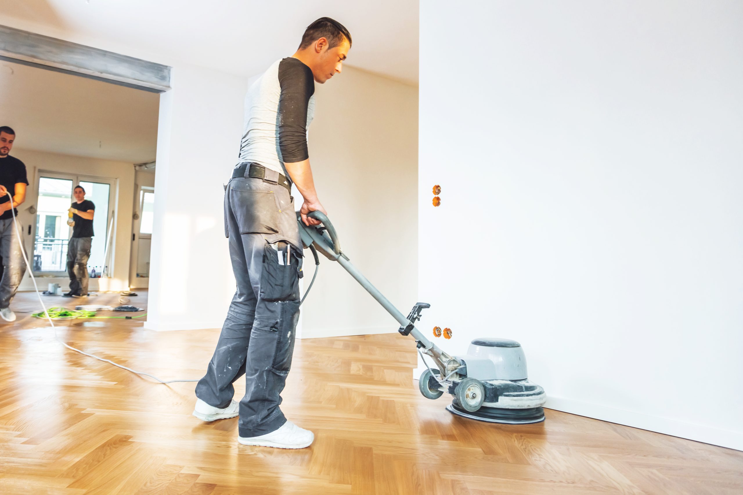 Technician giving a final rotary buff to an oak herringbone parquet floor in a Stanmore property after Dust-Free Floor Sanding, with a flawless satin sheen emerging.