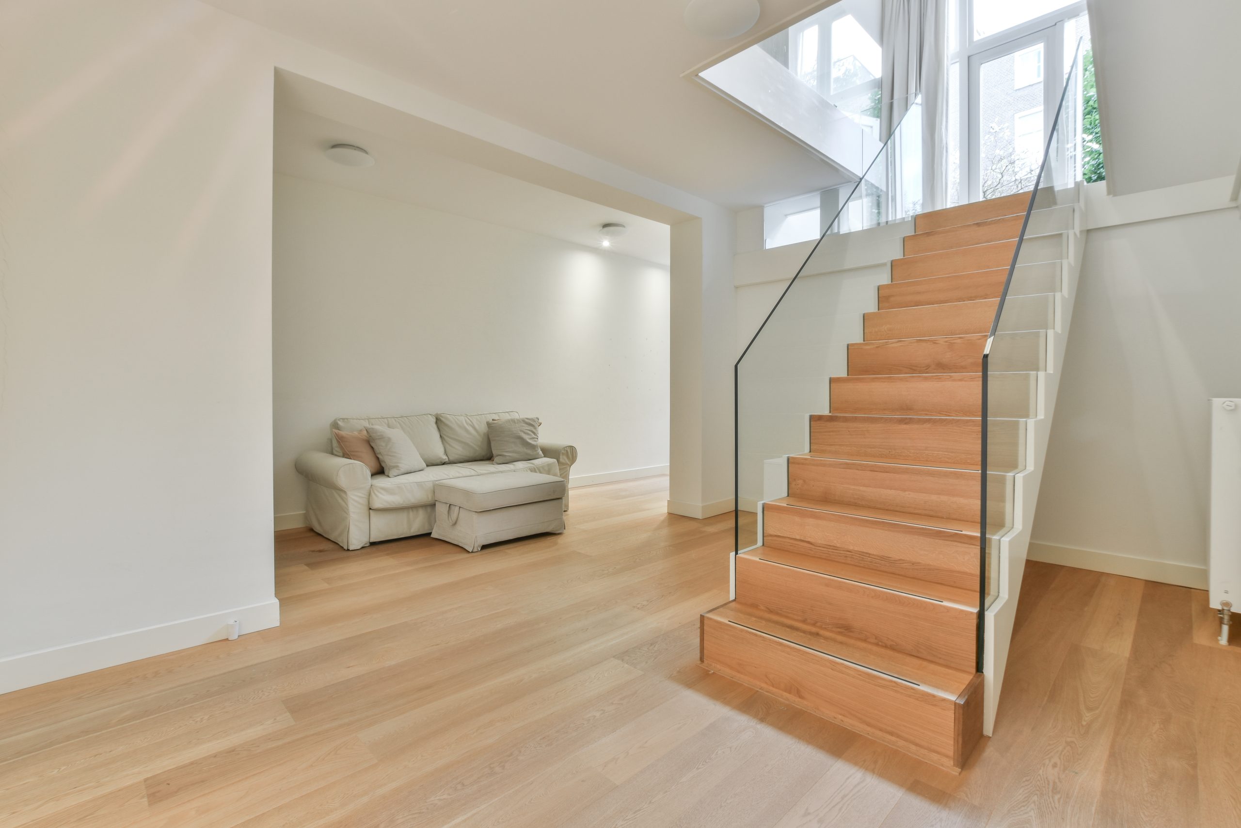 Wood Floor Sanding in Stanmore – smooth modern oak hardwood floor and matching staircase in a bright living room.