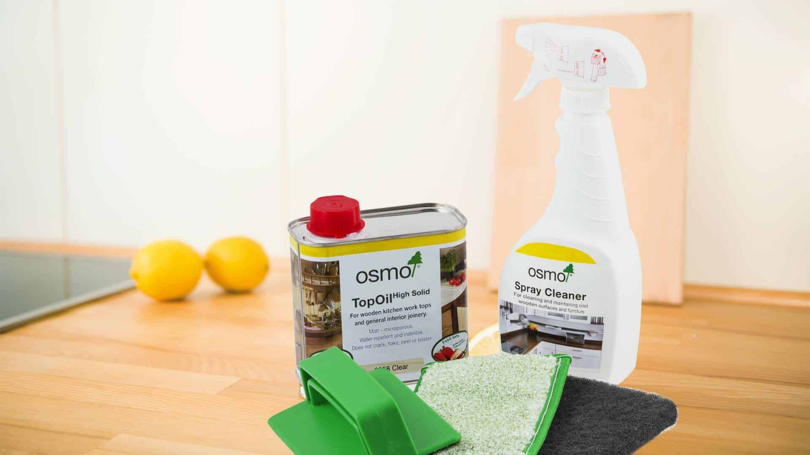 Osmo care products and pads on a solid oak kitchen worktop with matching oak plank floor in Stanmore, used for Worktop Refinishing maintenance.