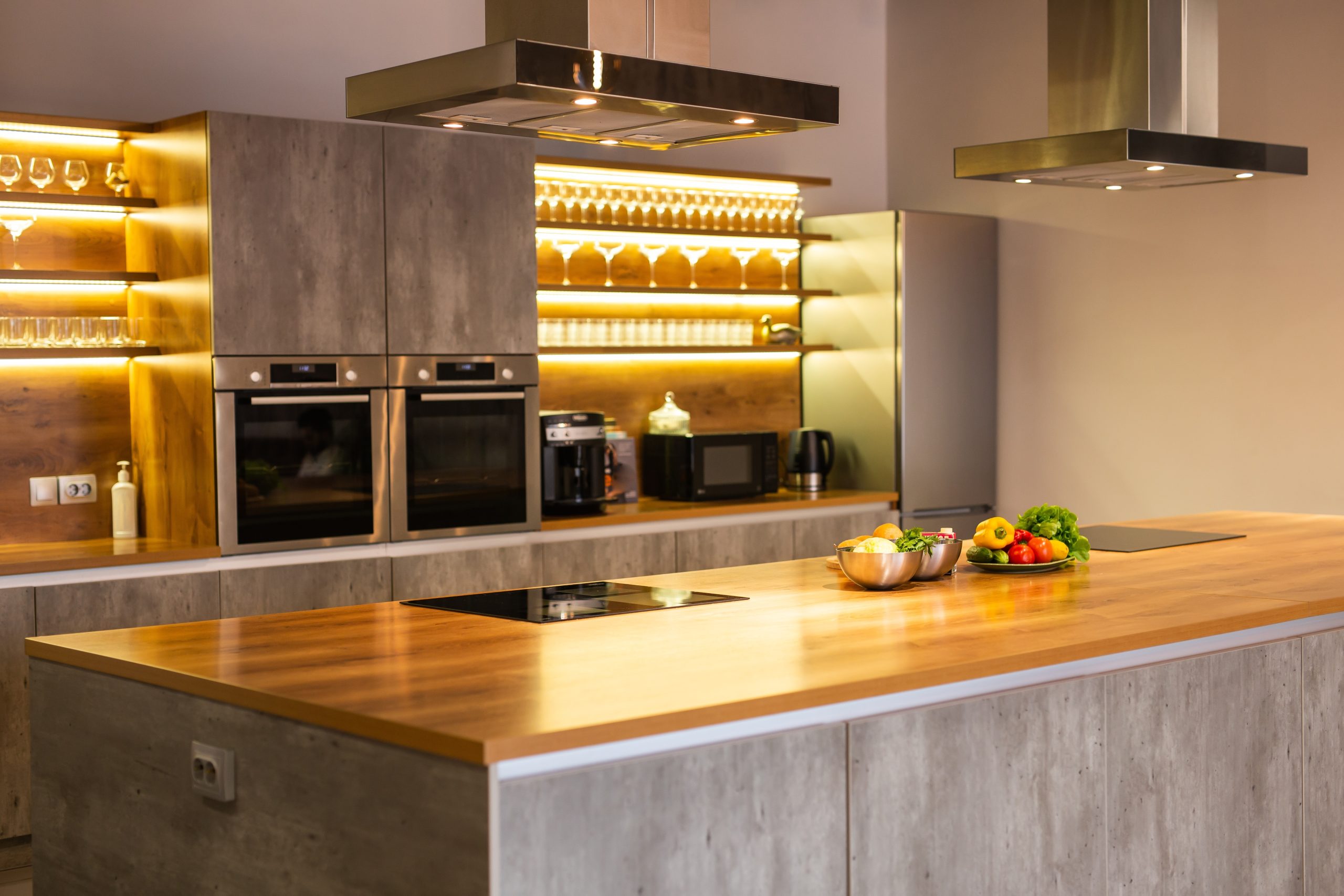 Modern kitchen with freshly restored solid wood island worktop and oak hardwood floor in Stanmore after professional Worktop Refinishing.