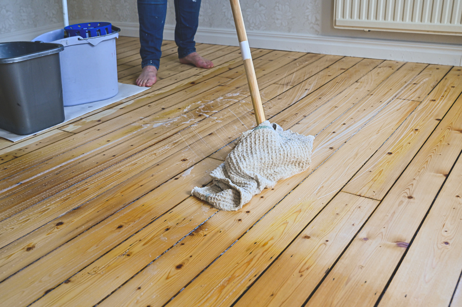 Wood Floor Sanding in Stanmore aftercare, showing gentle cleaning of sealed pine softwood floorboards with a damp mop to protect the new finish.