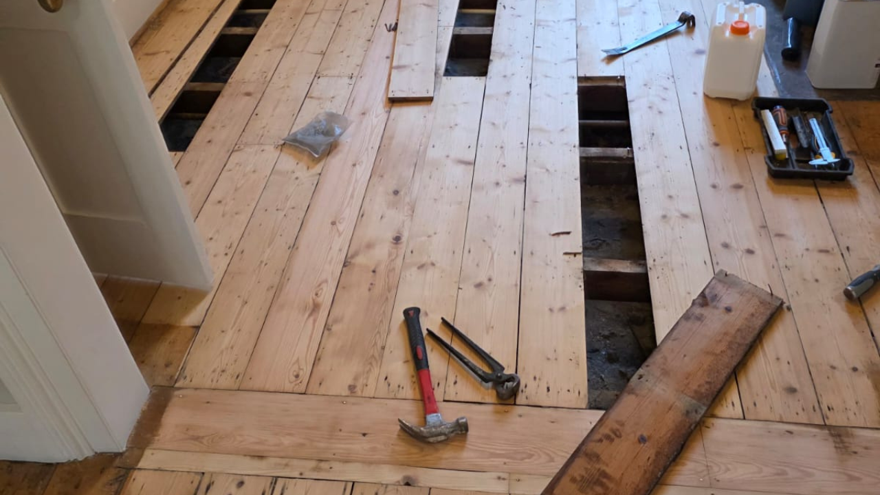Wood Floor Sanding in Stanmore with pine softwood floorboard repairs, showing lifted boards and subfloor access before sanding and refinishing.